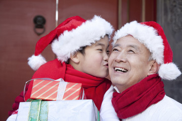 Grandpa and grandson holding Christmas Gifts