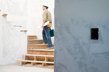 A builder walking up stairs