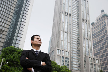 Fototapeta na wymiar Serious looking businessman near skyscrapers