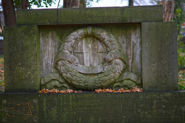 alter Grabstein mit Kranz
