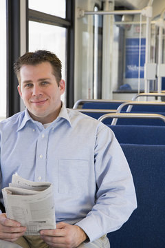 Man on train with newspaper