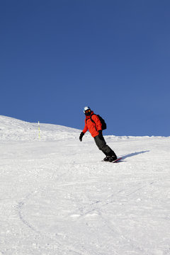 Snowboarder on ski slope at nice day