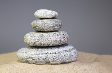 Fototapeta na wymiar vier gestapelte Steine im Sand