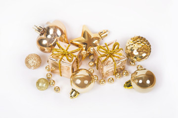 Gold gift with other Christmas baubles like holiday decoration on white.
