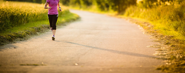 Detail of legs of a female runner on road - jog workout/well-bei - obrazy, fototapety, plakaty