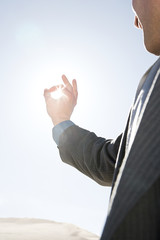 Man with fingers around sunlight