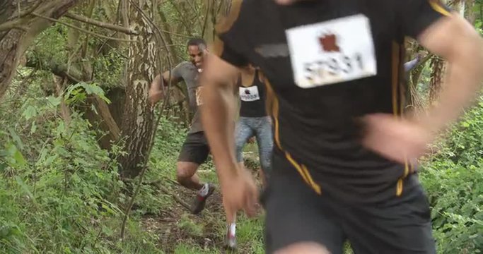 Competitors running through a forest at an endurance event