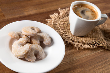 Christmas sweet rolls with coffee on brown wooden background.