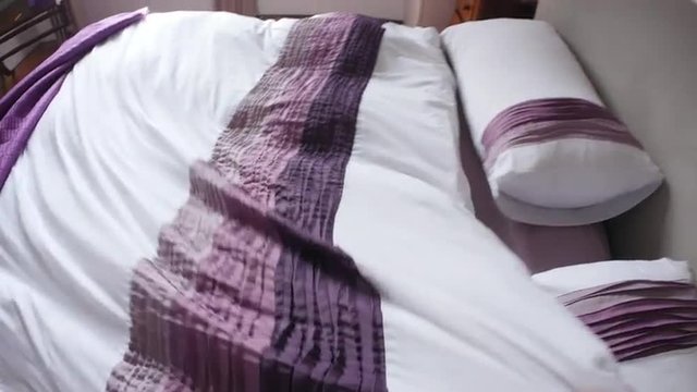 Point of view of man making bed up in the morning 