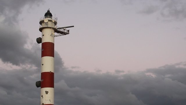Alter Leuchtturm, rot weisser Turm im abendlicht mit Wolkenhimmel