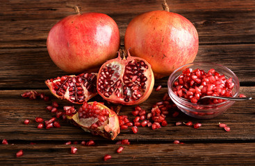 Pomegranate and glass bowl with beans on wooden board