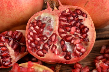 Pomegranate and glass bowl with beans on wooden board