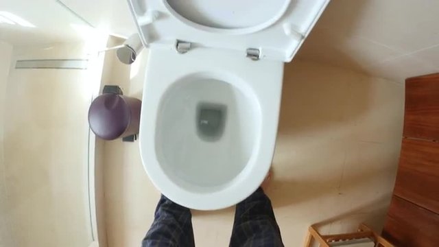 Point of view of man going to and using the toilet