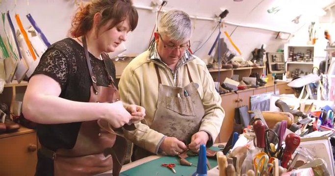 Apprentice In Bespoke Shoemaker Stitching Together Leather