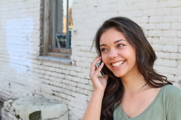 Beautiful teenager calling by phone outside with copy space on the left side 