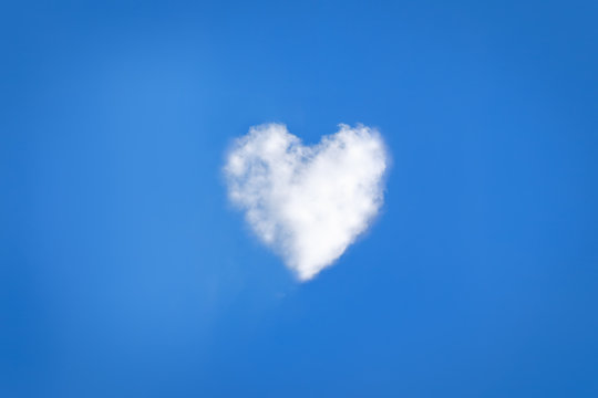 abstract heart shaped cloud with smiley face on blue sky 