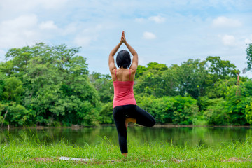 asian women practicing yoga in the garden background