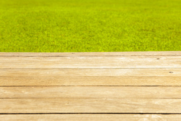 Fototapeta premium Wood planks floor with green grass on the background.
