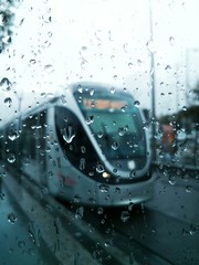 The Jerusalem Light Rail tram train at rainy day through the wet window glass with water drops © Eliricon