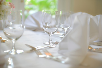 Glasses, Wine Glasses and plates on table in restaurant