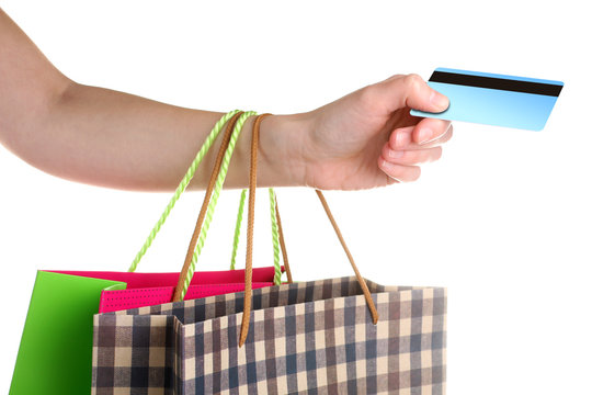 Colorful shopping bags for purchases with a credit card in the hands of a woman on an isolated background