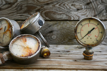 Old pressure gauge on wooden background and empty area for text, damage gauge from operation oil...