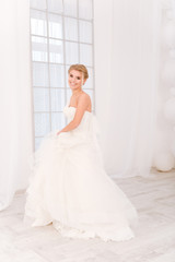 Fototapeta premium Smiling bride standing in white wedding dress