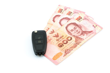 Car keys and money baht Thailand on a white background