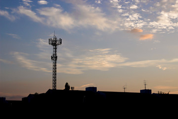 Several radio towers with sunset sky in background