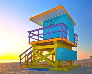 Sunrise in Miami Beach Florida, with a colorful lifeguard house in a typical Art Deco architecture,...