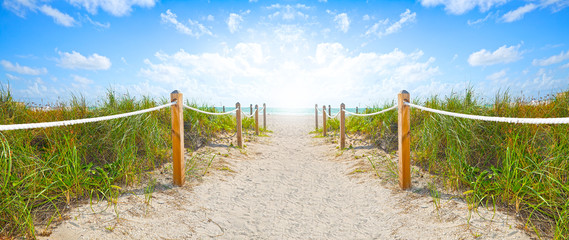 Sandweg zum Strand und Meer in Miami Beach Florida, an einem schönen Sommermorgen mit blauem Himmel