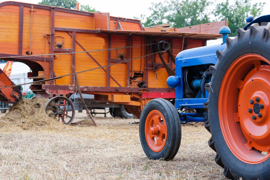 Perspective view of and old tractor and a straw baler, agriculture, rural life