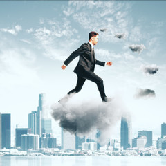 Businessman climbing thecloud ladder at city background concept