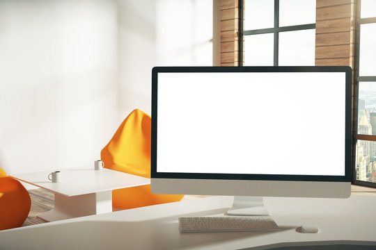 Blank white computer screen on the table in the modern office, m