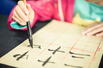 Chinese children learn to write Chinese characters, calligraphy is the traditional culture of China - Powered by Adobe