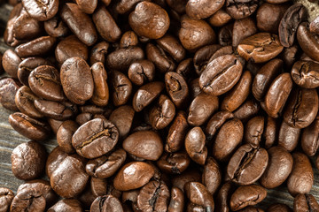 Viele Kaffeebohnen liegen auf einen Tisch verstreut. Nahaufnahme 