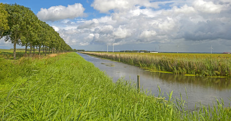 Clouds over a canal through a rural landscape 