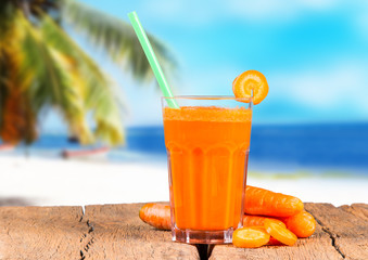 Glasses of carrot juice with vegetables on table