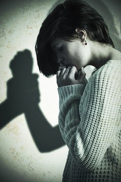 Composite image of sad pretty brunette holding her head