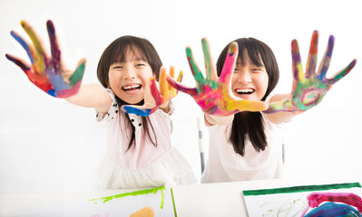 happy little girls with hands in the paint