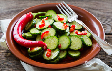 Fresh salad of cucumbers with red hot chili pepper
