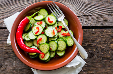 Fresh salad of cucumbers with red hot chili pepper