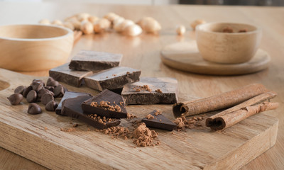 Dark chocolate with cocoa on wooden table