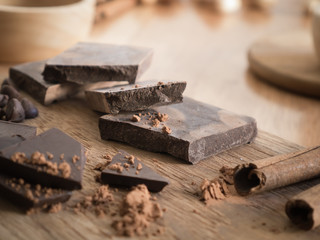 Dark chocolate with cocoa on wooden table