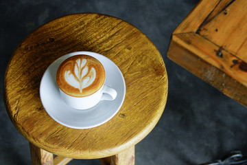 A Cup of Tulip Cappuccino on A Yellow Wooden Stool