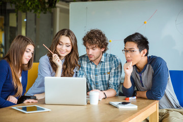 Group of students using laptop together