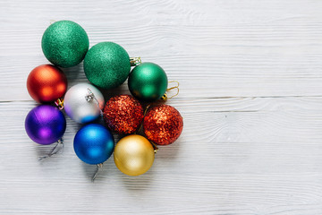 Colored Christmas decorations on a white wooden table.