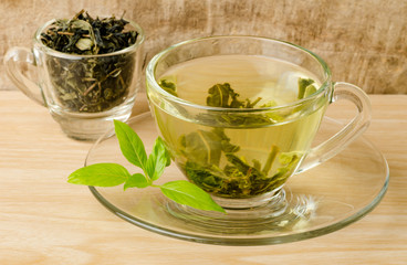 The cup of hot green tea (Healthy drink) on wooden background