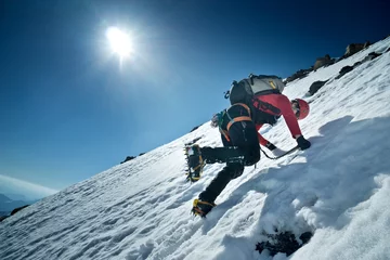 Keuken foto achterwand Alpinisme Bergbeklimmer beklimt de noordwand van Fuscherkarkopf, Oostenrijk. Klimmers slaan met stijgijzers op treden in het ijs.