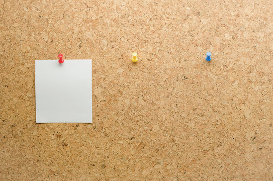 Paper card posted on a cork board with tack pin and waiting pape